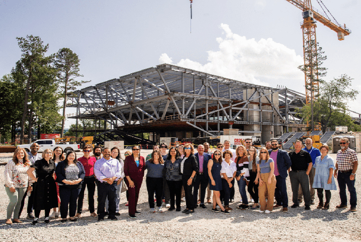 AWSOM faculty and staff stand in front of the construction site for the School